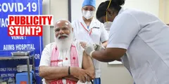 प्रधानमंत्री नरेंद्र मोदी का चुनावों के बीच पब्लिसिटी स्टंटः असम का गामोसा पहन कर  केरल और पुदुचेरी की नर्स से लगावाया कोविड टीका 
